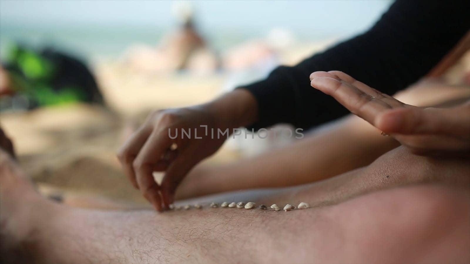 Lazy time. Feet of the man on the beach in the sand on a summer day. Each puts a grain of sand on the foot of the other gays on vacation.