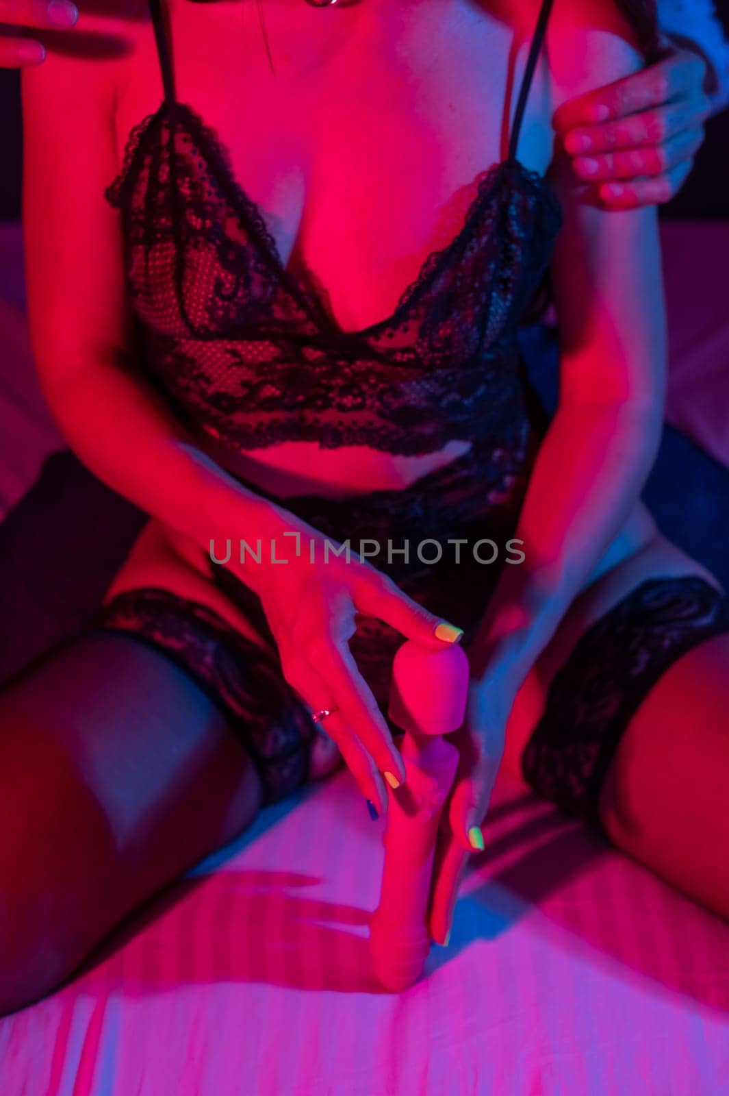 Man and woman in bedroom in red blue neon light using dildo