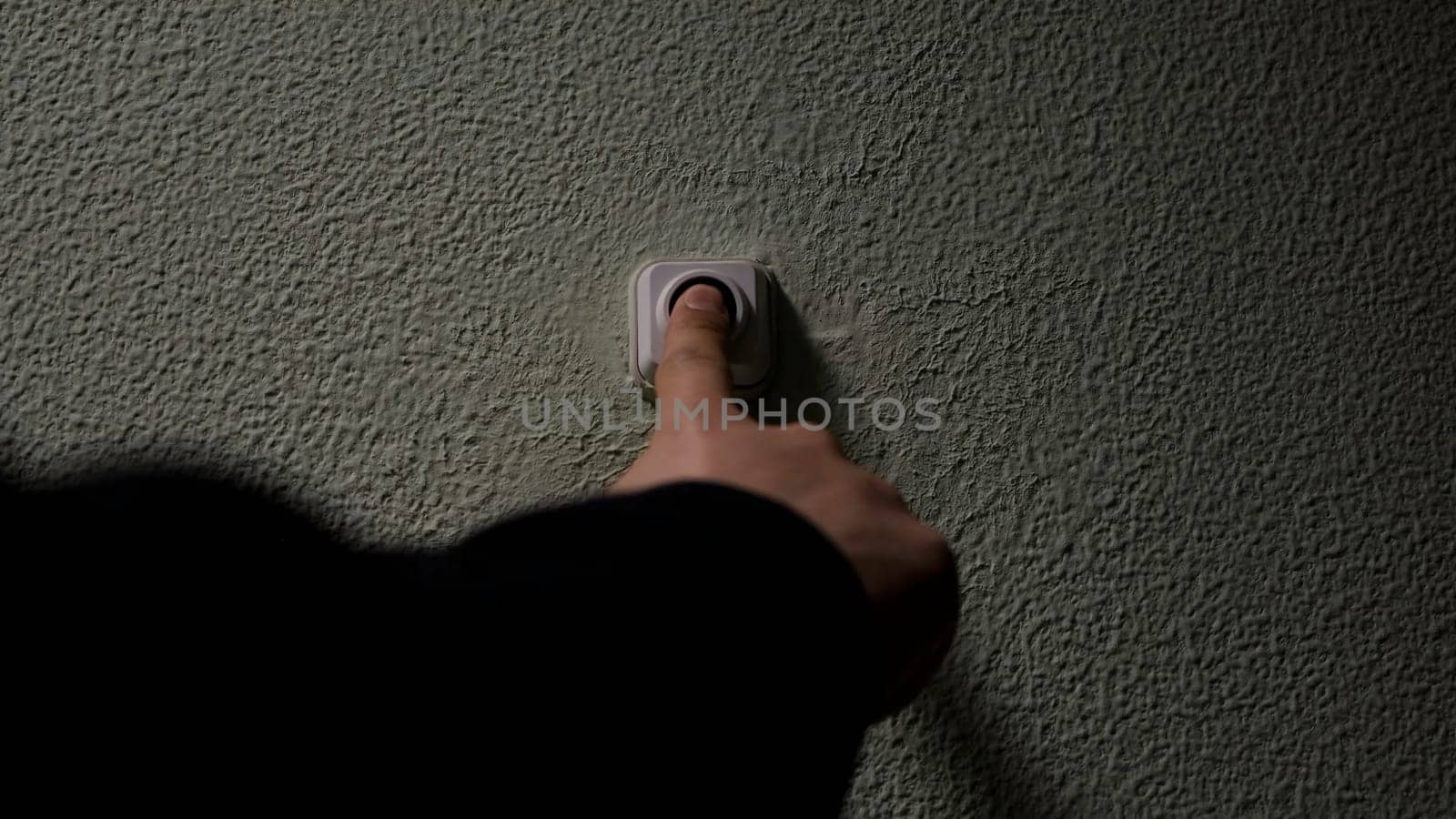 Close up of a male finger pressing a ring bell in the evening. Concept. Impatient man pressing button of a door bell