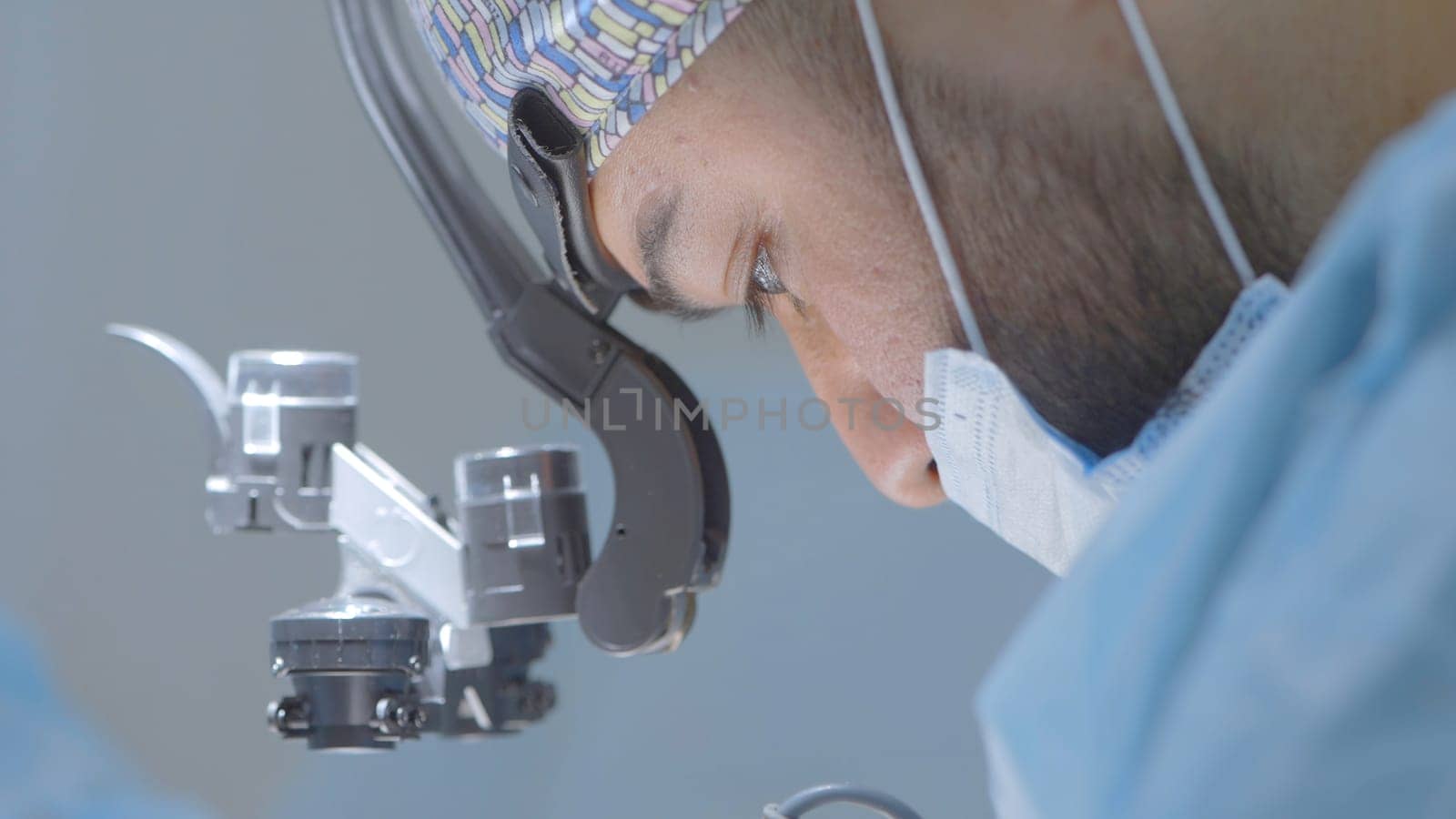 Close-up of surgeon performing operation. Action. Focused and serious surgery by surgeon. Professional surgeon at work on operation with anesthesia.