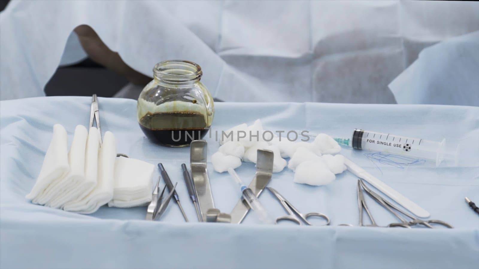 Surgical equipment set for surgery in operation room in the hospital. Close up of medical tools, iodine cup and white cotton balls and sterile gauze, concept of medicine.