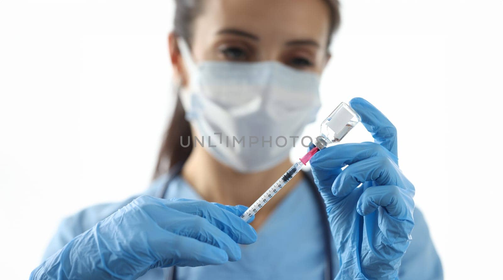 Doctor drawing medicine into syringe from vial closeup. Vaccination against coronavirus infection concept