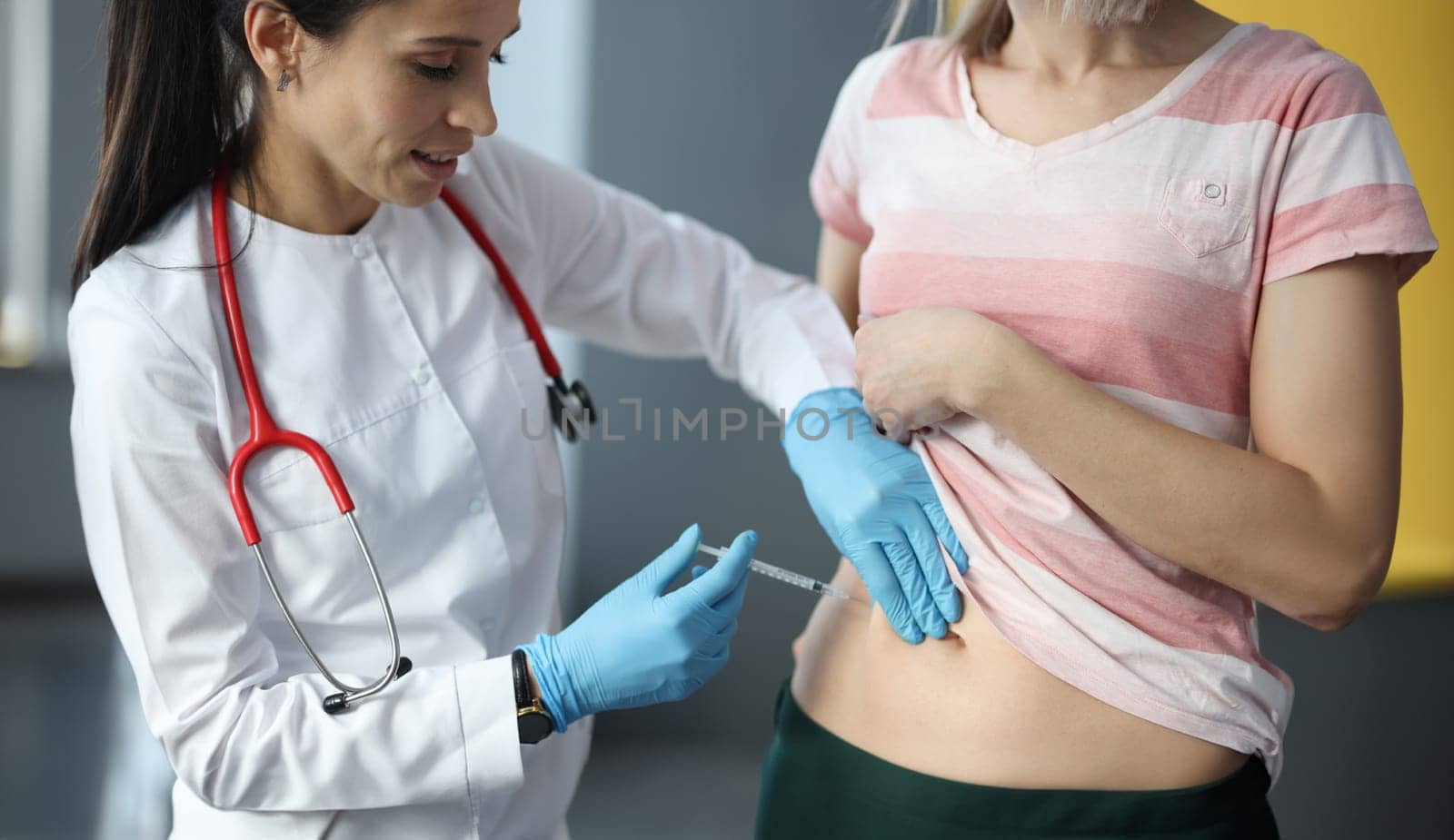 Doctor making injection of insulin into abdomen of female patient. Diabetes mellitus treatment concept
