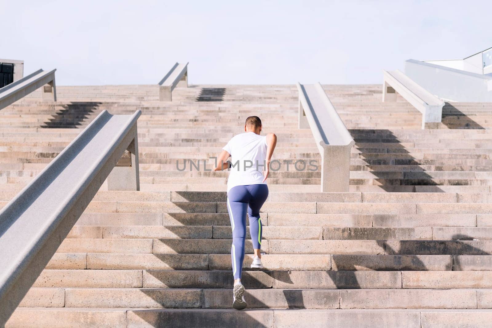 rear view of an unrecognizable sports woman training on stairs, concept of active and healthy lifestyle, copy space for text