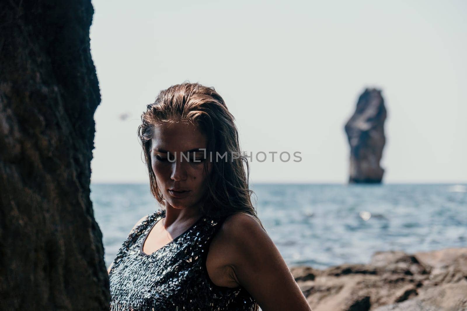 Woman summer travel sea. Happy tourist enjoy taking picture outdoors for memories. Woman traveler posing on the beach at sea surrounded by volcanic mountains, sharing travel adventure journey by panophotograph