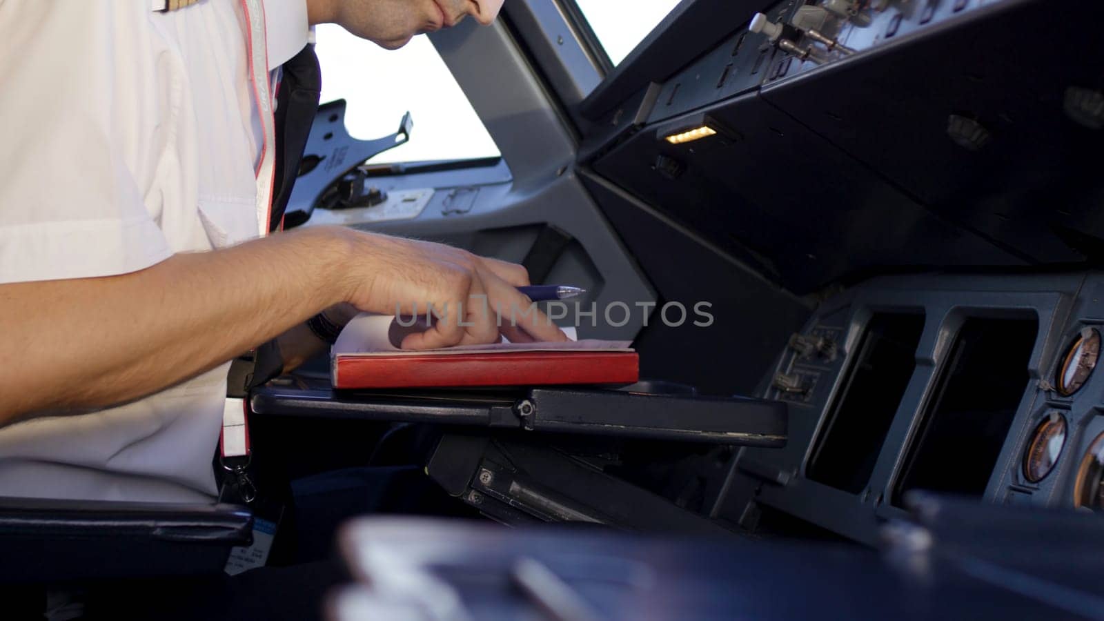Rear view of pilot operating controls of corporate jet. the pilot checks all the systems. Rear view of pilot and copilot operating controls of corporate jet. Pilot and copilot in commercial plane