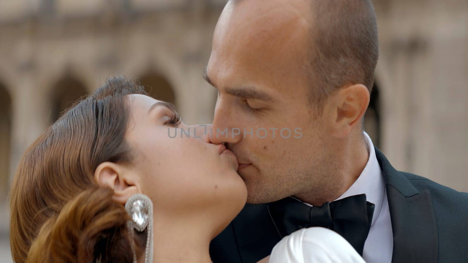 Romantic red haired lady and an elegant gentleman looking at each other with love. Action. Date outdoors on a city background