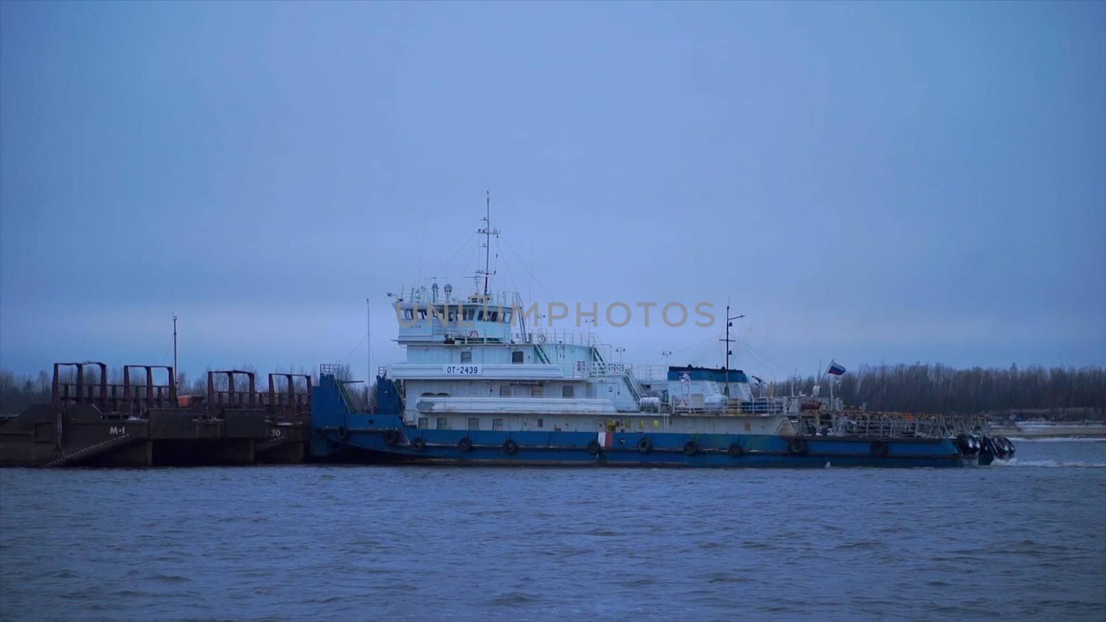 Navigation on the Volga river, sailing ship on blue sky background. Clip. Concept of water transport, a large ship and a wide rippling river