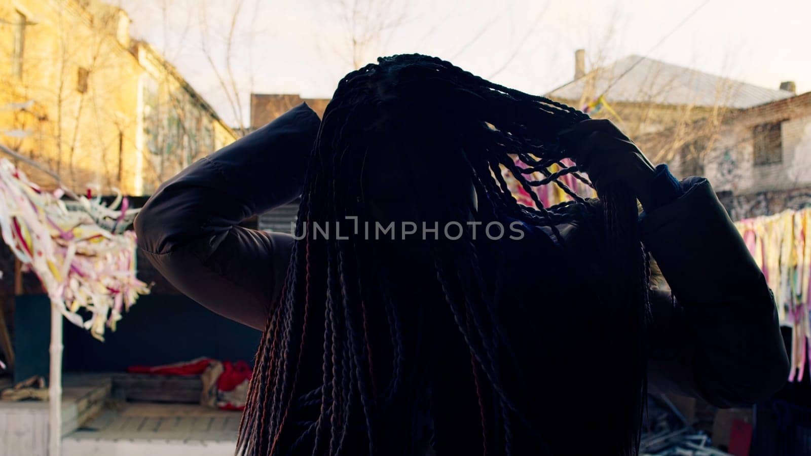 Young woman spinning with colorful dreadlocks. Stock footage. Stylish woman with dreadlocks turns to show them off. Beautiful woman with dreadlocks at theme festival.