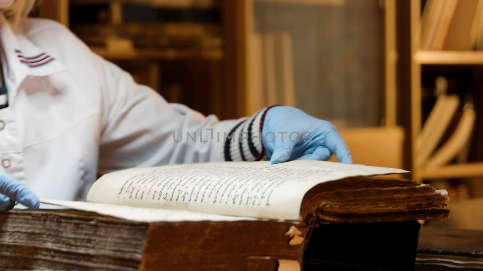 The master is restoring an old book. Stock footage. Close up of a book restorer hands turning pages slowly
