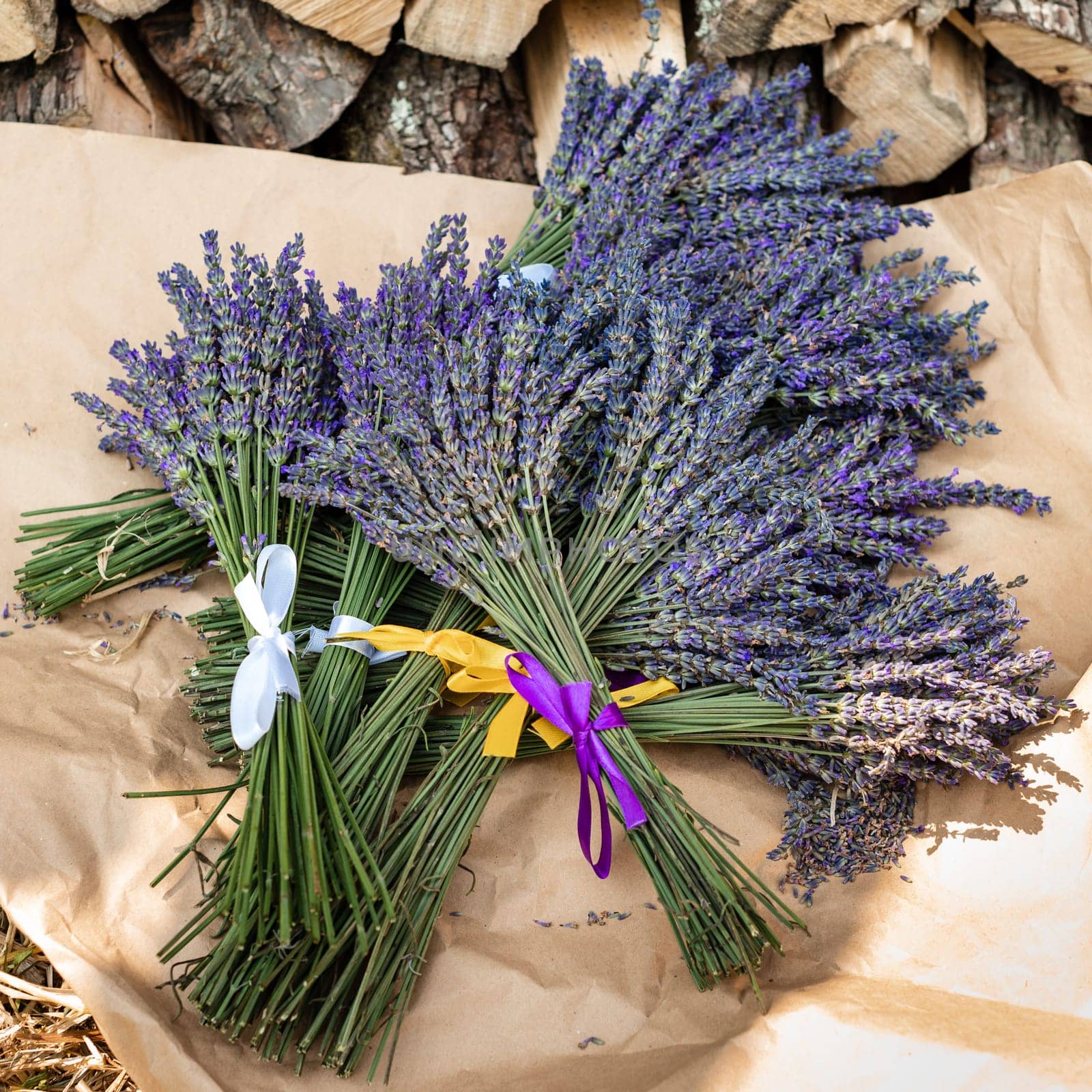 Lavender bouquets with purple and yellow ribbons lie on kraft paper