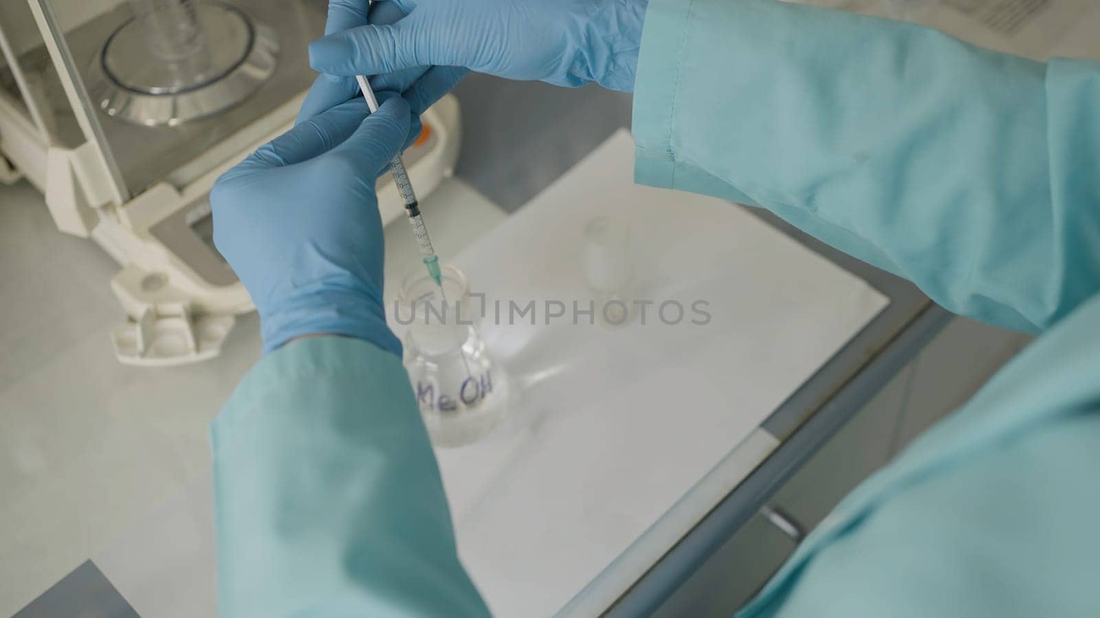 Close up of scientist in protective uniform drawing up medical solution into a syringe. Action. Concept of science and medicine