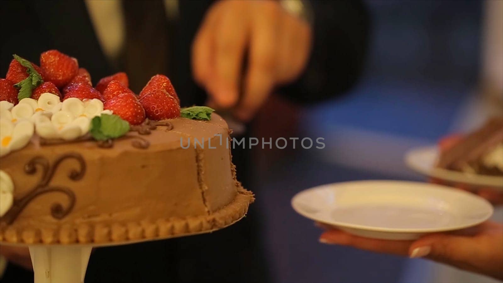 Hands of bride and groom cut of a slice of a wedding cake. Cut the wedding cake. people cut and put the cake on a plate. White and chocolate cake. Knife.Wedding. Celebration HD