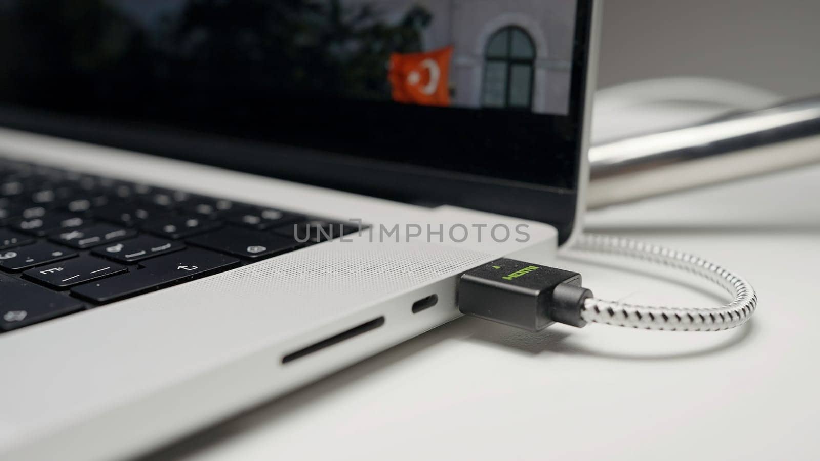 Closeup of USB flash drive inserted into port on the side of a laptop. Action. Part of laptop with a screen and movie