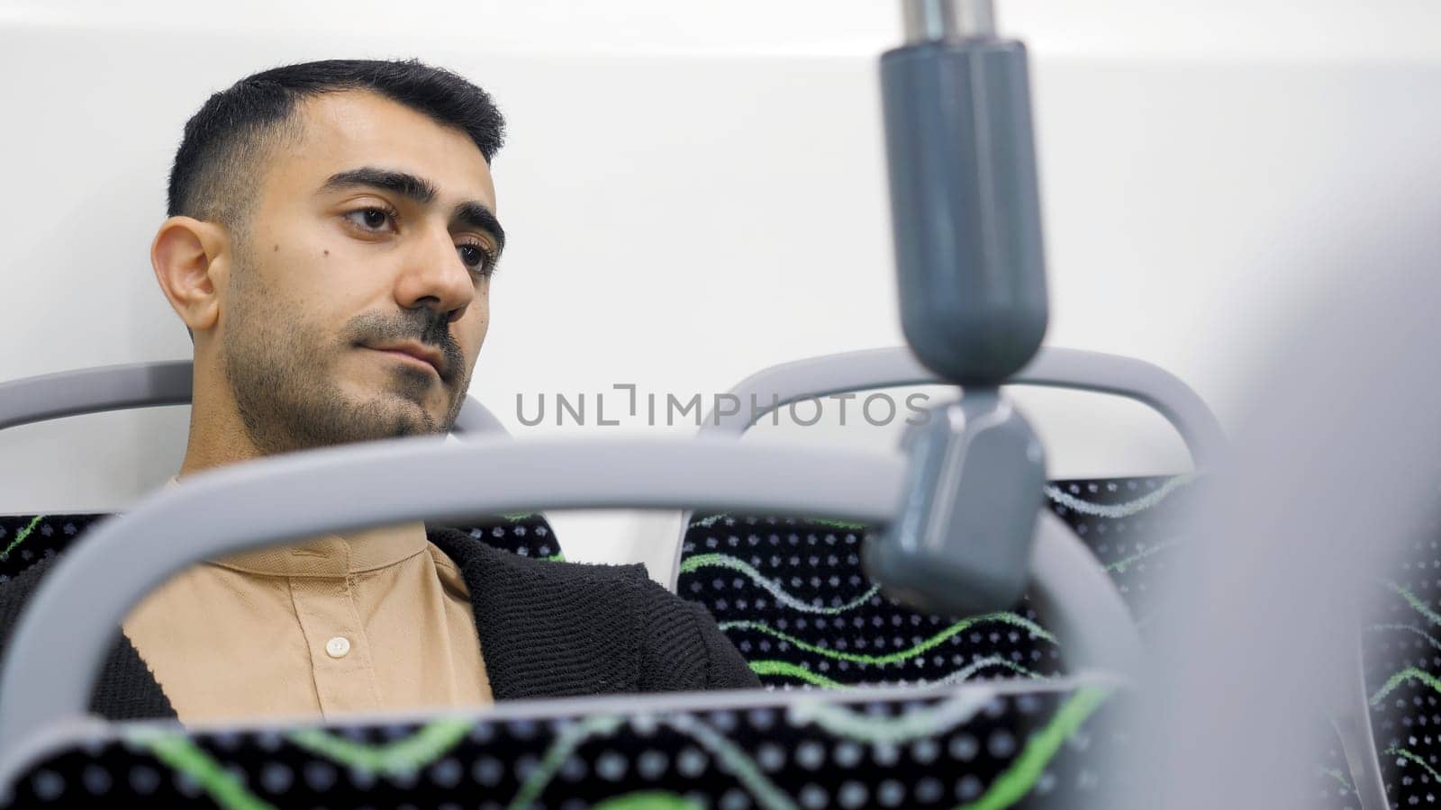 Man rides alone on public transport. Media. Man looks at phone and rides bus. Man checks phone on way on traveling bus.