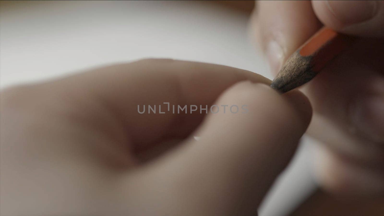 Man nervously twirls a pencil in your hand close up. Close up of hand holding a pencil. Fingers hold a pencil macro shoot. Man's hand holding a pencil to writing on paper.