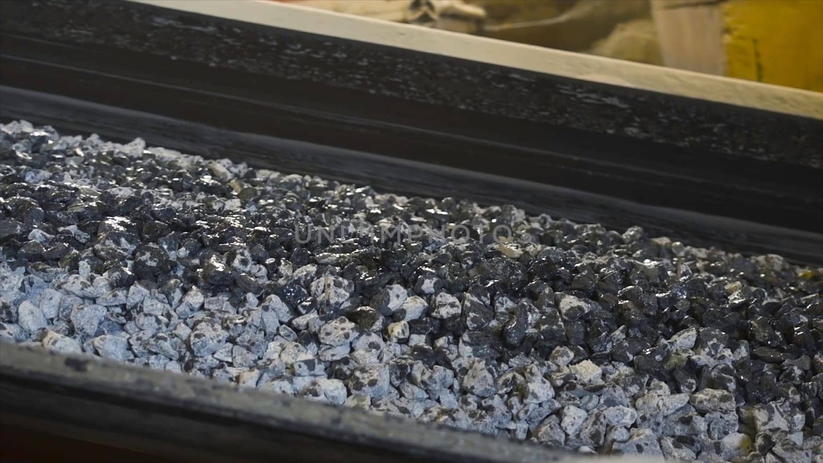Pile of coal moves on belt conveyor at factory. Stock footage. Processing of raw materials or coal at plant. Conveyor for moving mass of raw materials during processing.