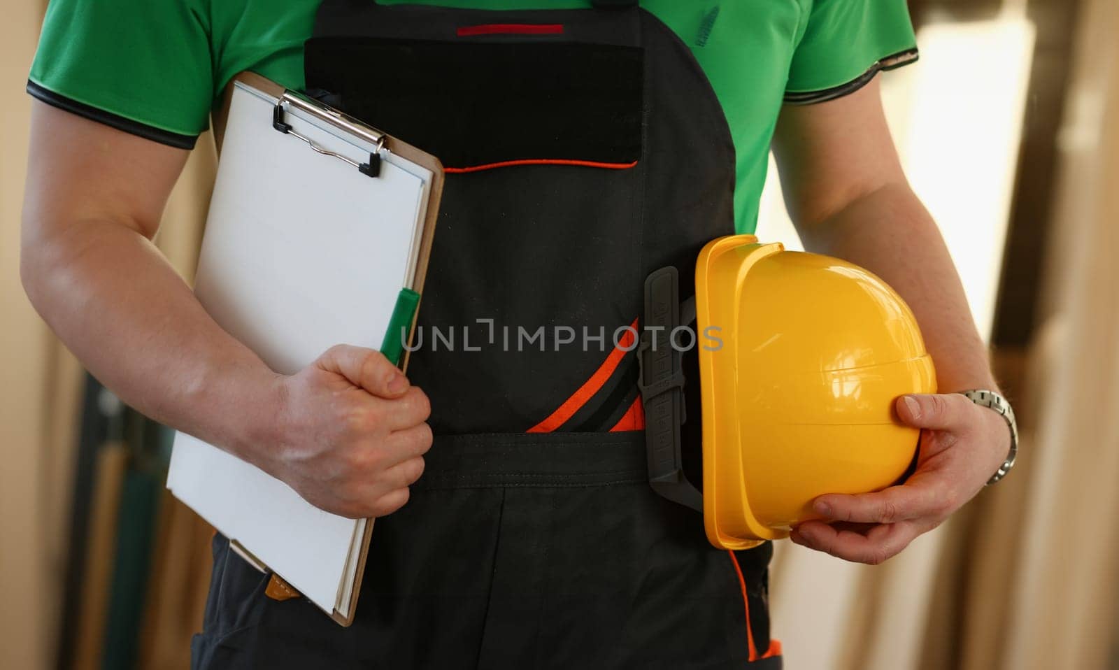 Man builder holding documents and safety helmet in his hands closeup. Quality repair services concept