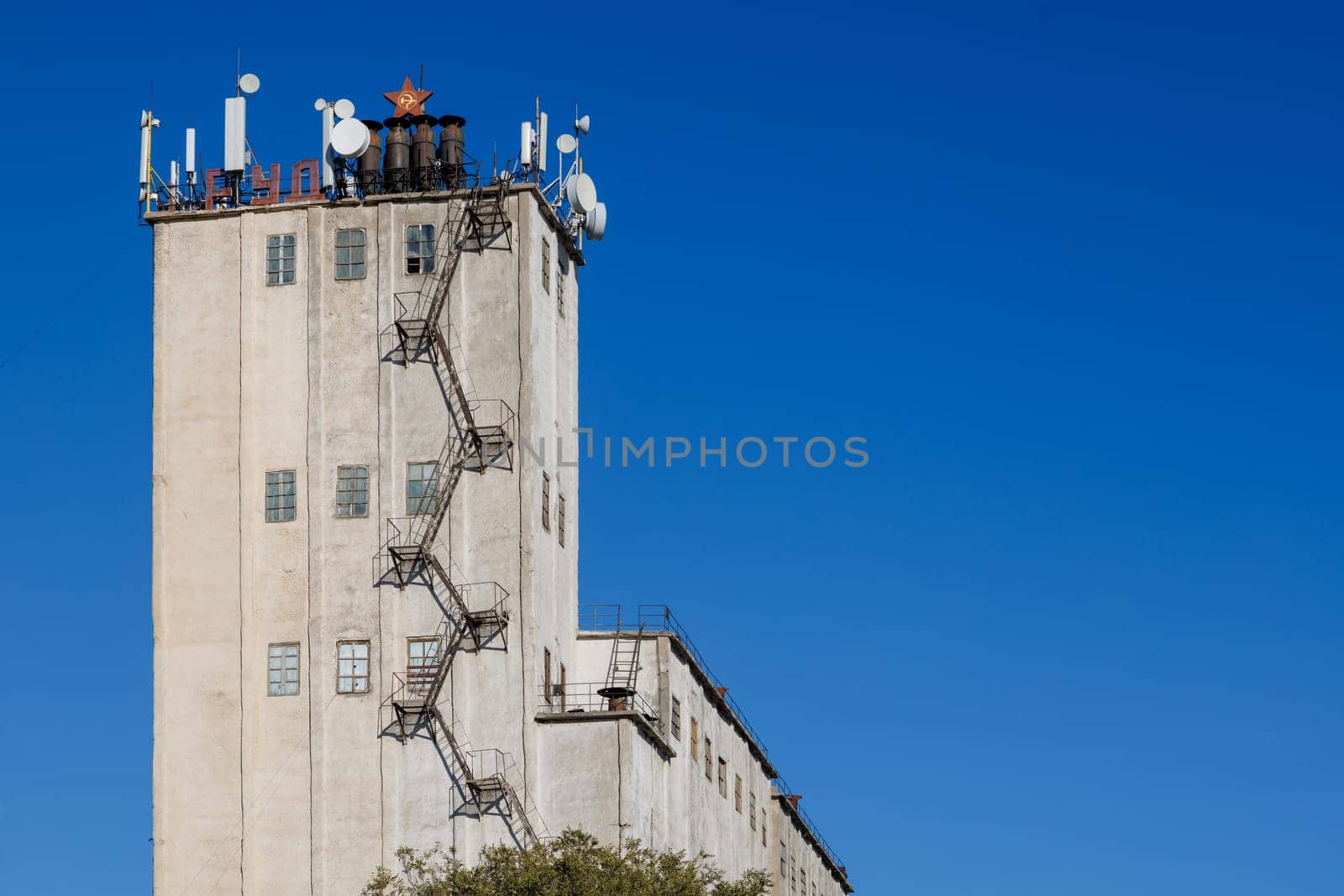 telecommunication antennas on top of old soviet elevator tower, letters means labor