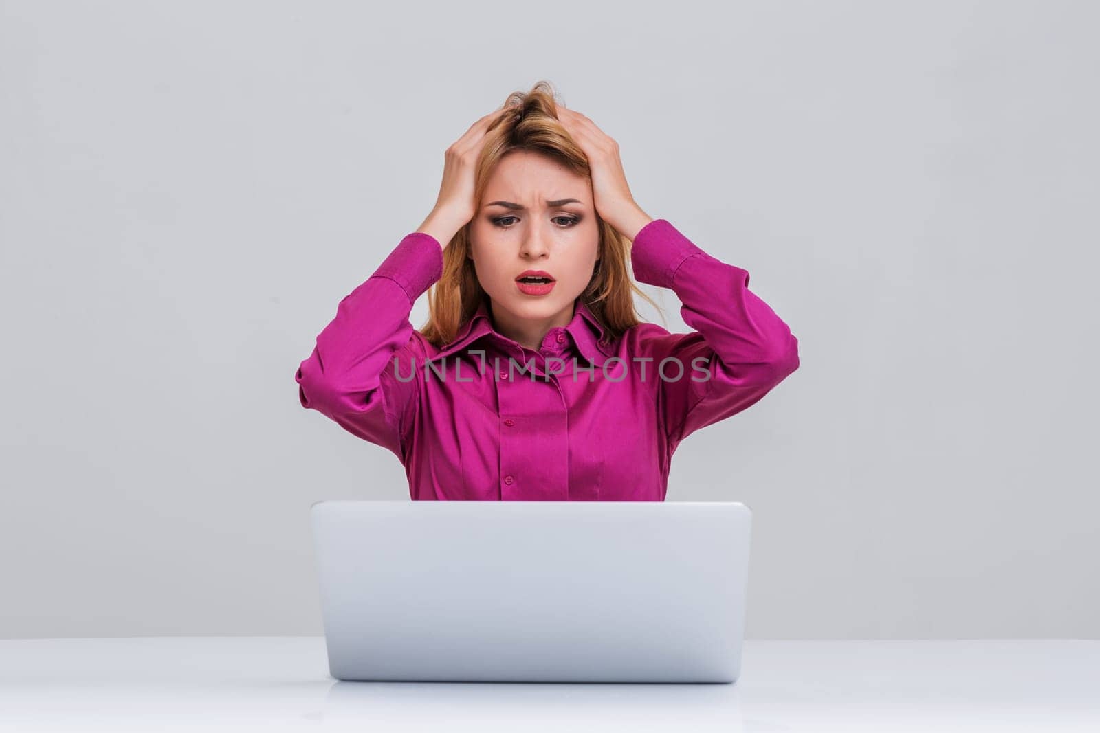 Young businesswoman working at laptop computer. she is going through. her head in her hands