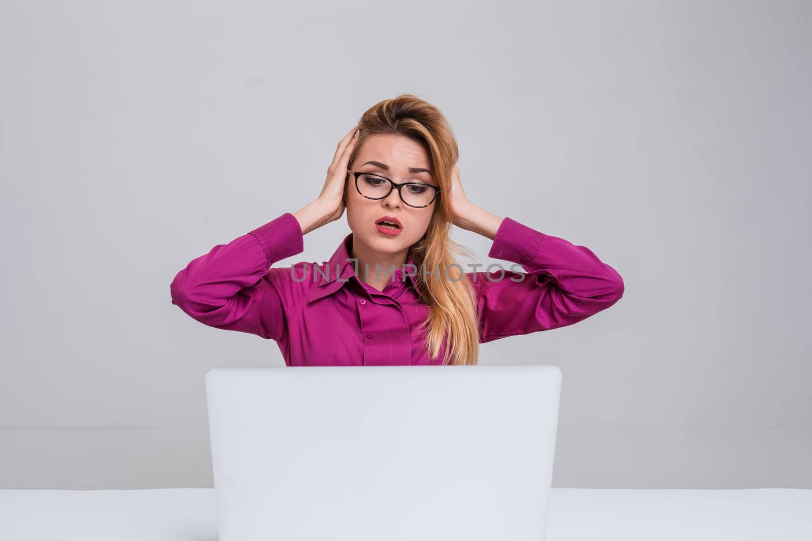 Young businesswoman working at laptop computer. she is going through and looking at the monitor. her head in her hands