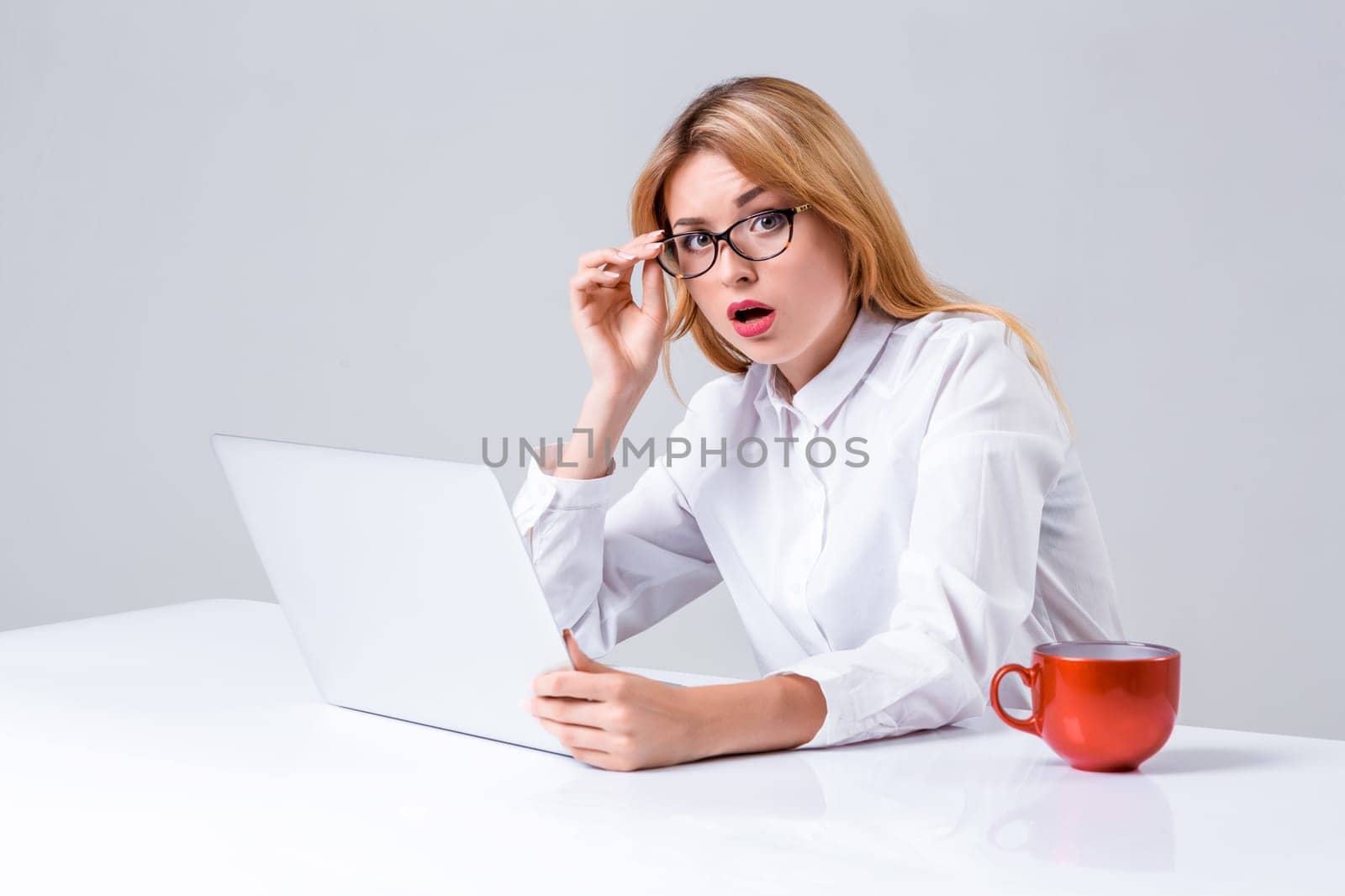 Young businesswoman working at laptop computer. she was surprised, prints and looking at camera