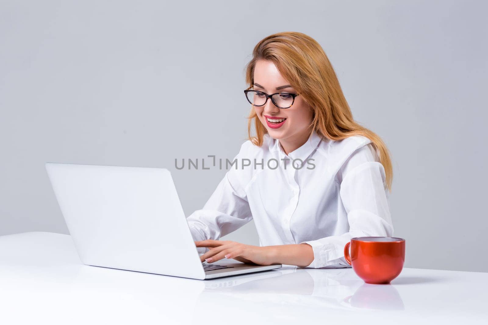 young woman sitting in the table and using laptop by nazarovsergey