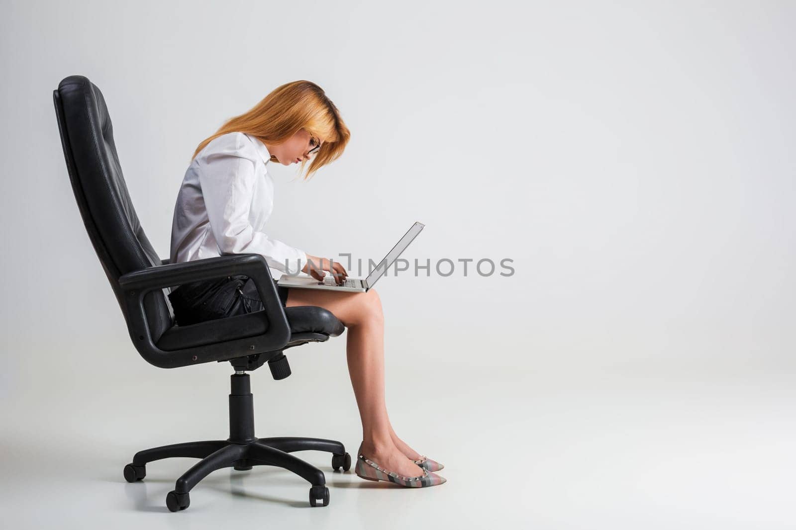 young woman sitting on the chair and using laptop by nazarovsergey