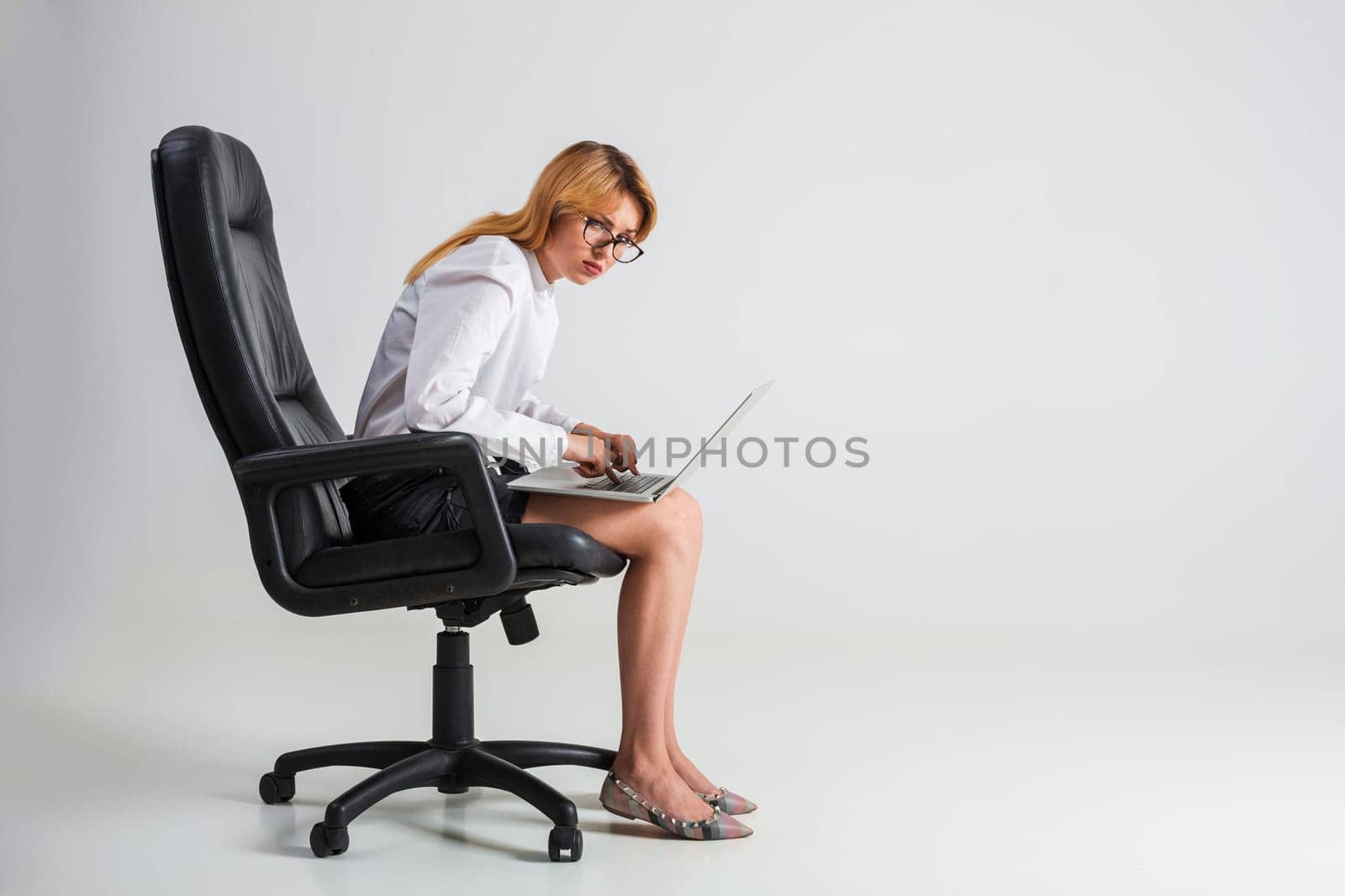 young woman sitting on the chair and using laptop by nazarovsergey