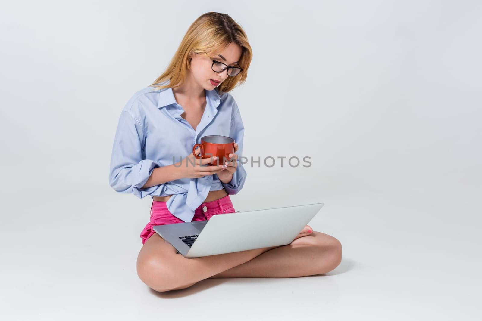 young woman sitting on the floor and using laptop by nazarovsergey