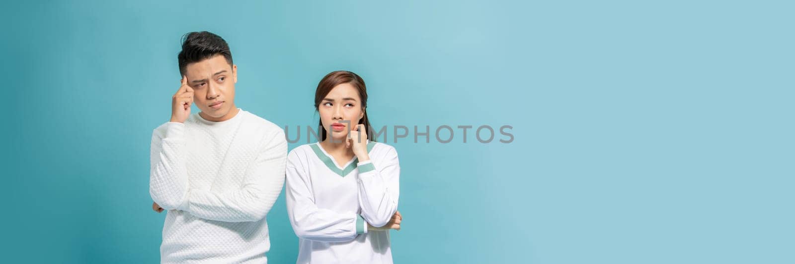 Sad pensive husband wife arm chin looking empty space isolated on turquoise background