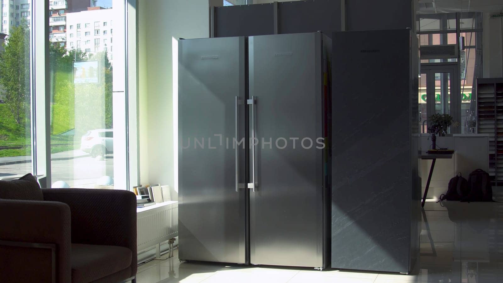 Refrigerator with two doors. Household utensils. Modern design of adjacent refrigerator with two large doors. Two large compartments for freezing and storage in double refrigerator.