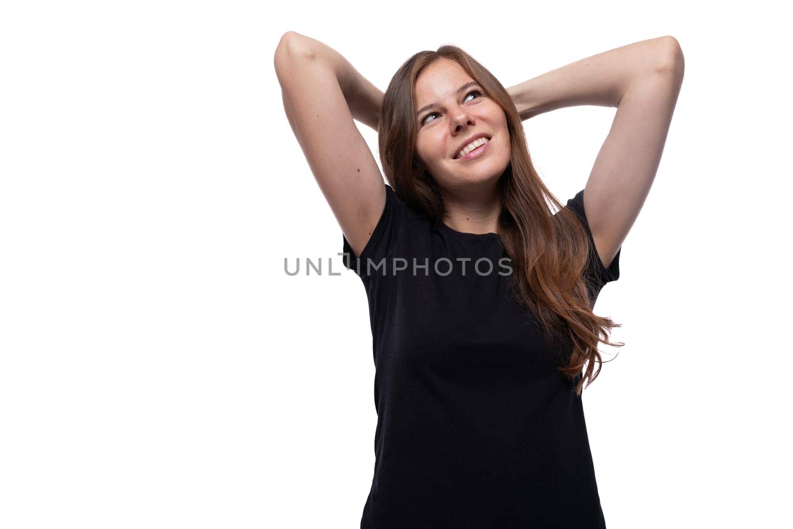 Dreamy young woman with straight hair wearing a black T-shirt on a white background by TRMK