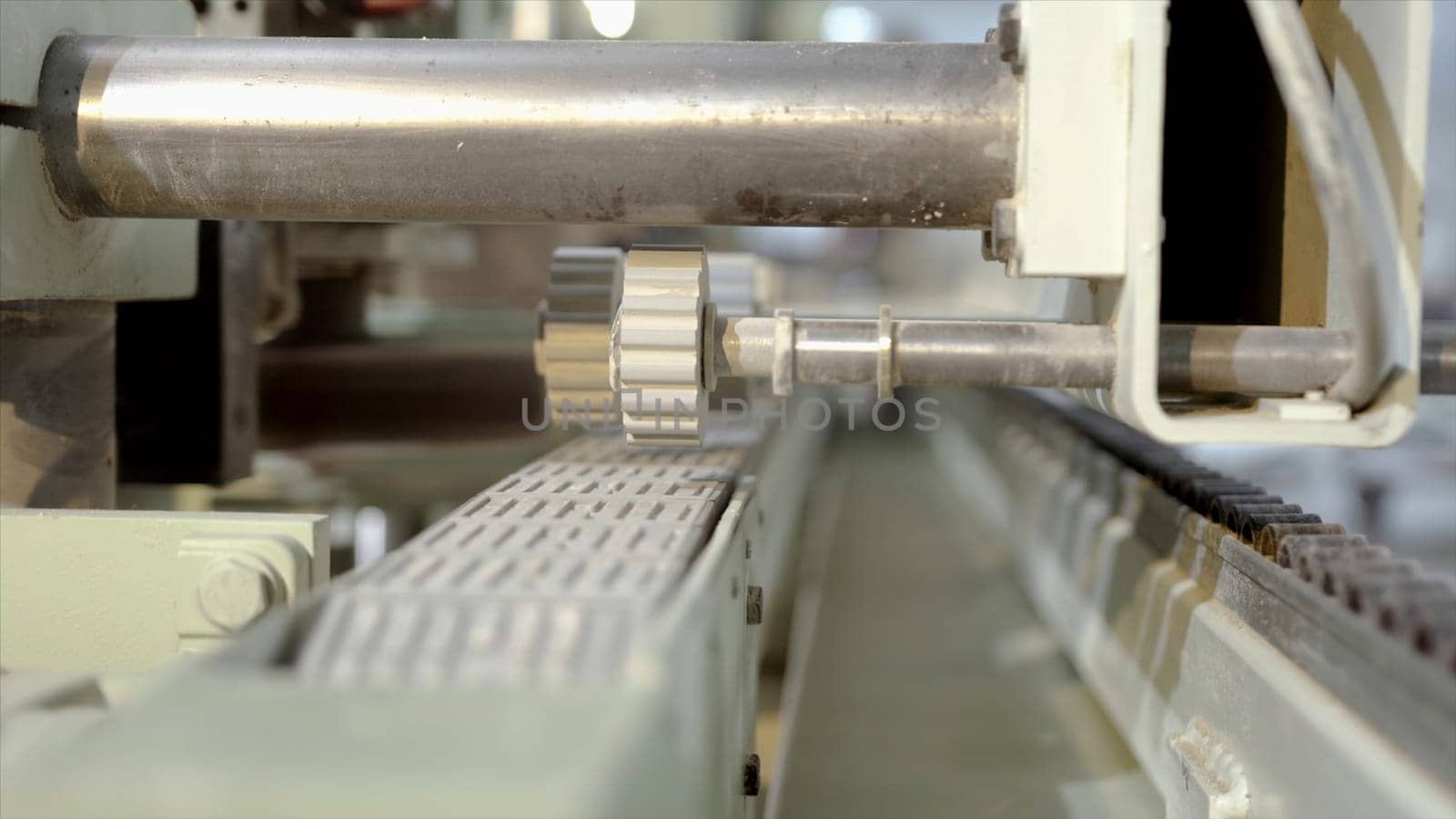 Close-up of machine for rolling parts. Action. Automated machine with rotating gears for rolling products. Industrial enterprise with new machines for processing wood products.