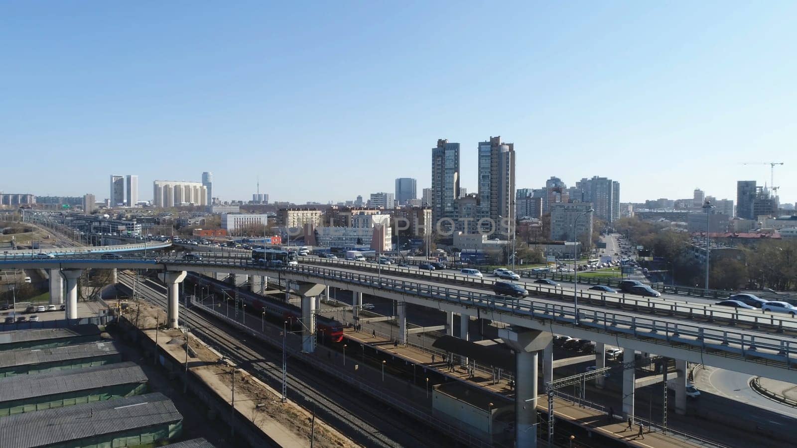 Top view of big city with high-rise buildings and traffic on roads. Scene. Beautiful metropolis in daytime is immersed in bustling traffic on roads of city.