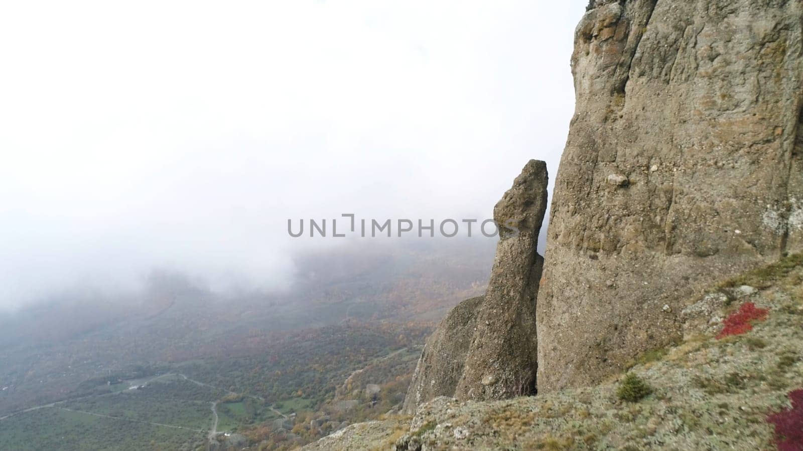 Nature landscape, view from the top of the hill on yellow and green valley in thick fog. Aerial for steep slope of a mountain, green and dry fields in foggy clouds.