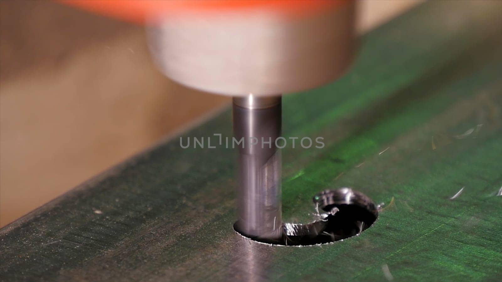 Hole being drilled into metal. Drilling closeup in metal workshop. Employee drill in flat steel plate with bench drill. Industry in slow motion HD