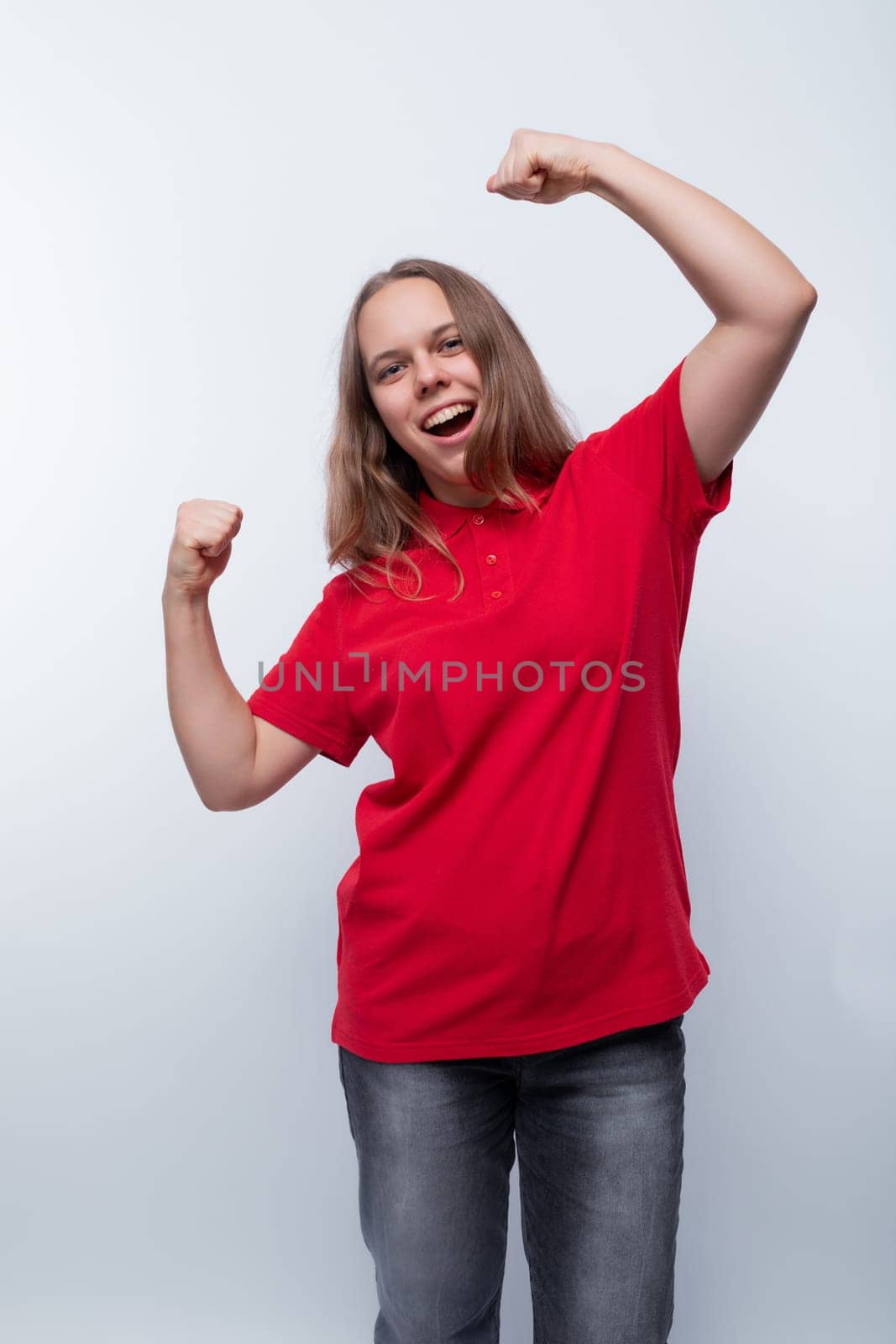 Joyful cute teenager girl wearing a red t-shirt by TRMK