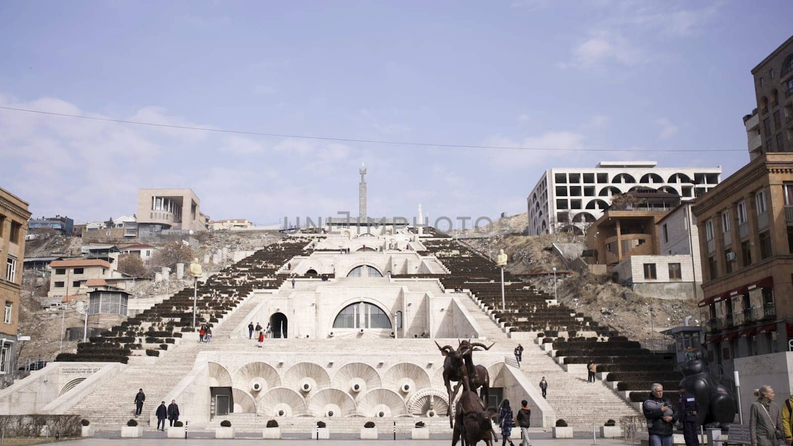 Park in Yerevan with cascade stairs, Armenia. Historical architectural complex with many stairs, fountains, and monuments on blue cloudy sky background.