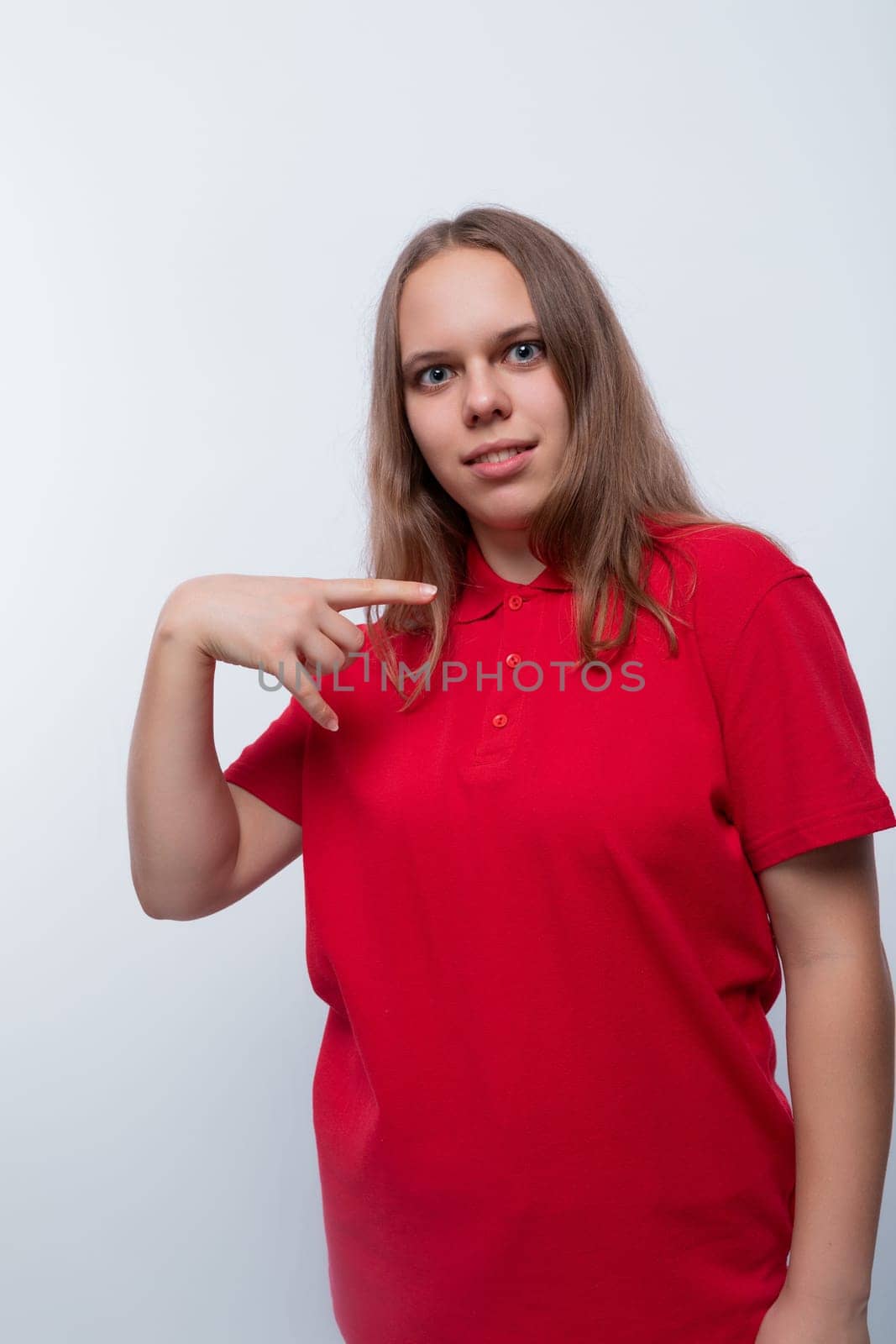 Caucasian girl with brown hair is wearing a red T-shirt.