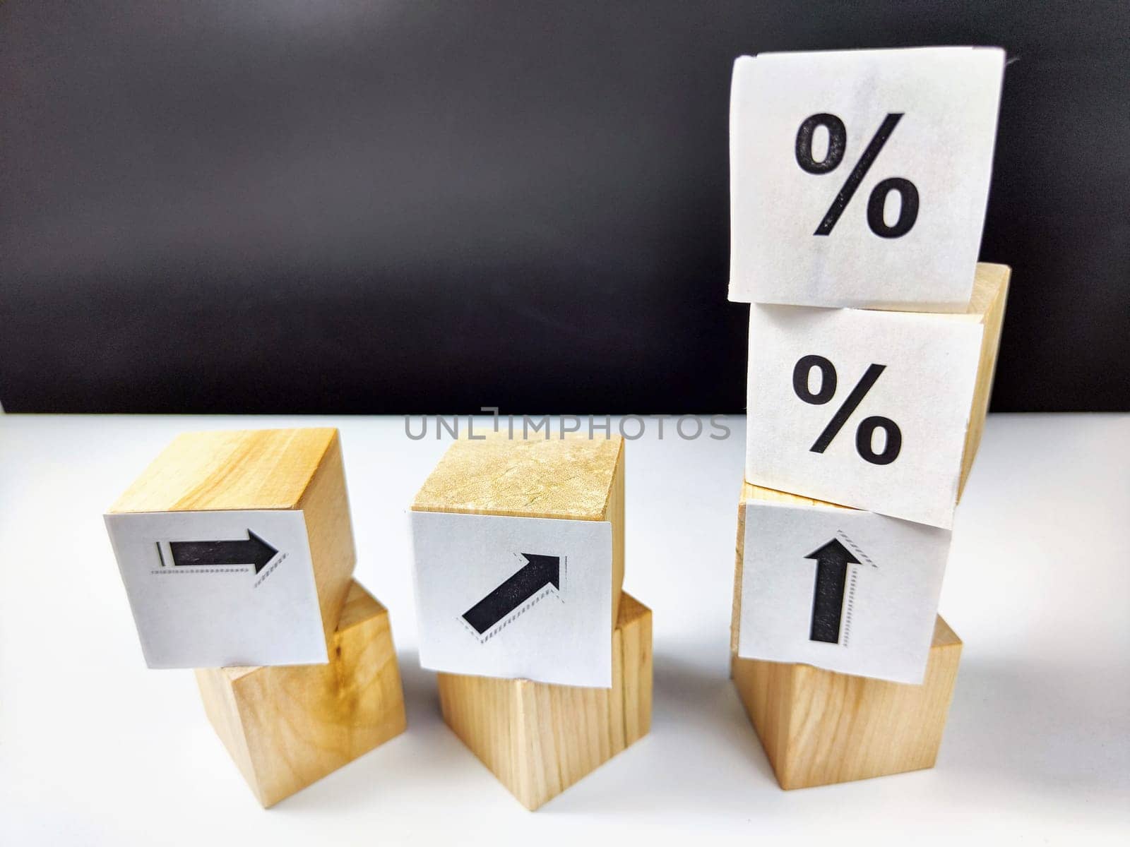 Wooden cubes with arrows and percentages on black background. Stages of action and goal achievement. Planning. Business actions. Receiving income and profit