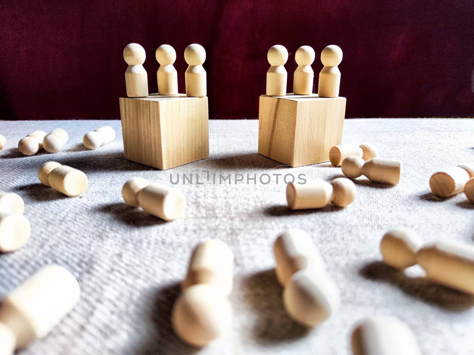 Wooden toys stand opposite and lot of lying figures. Concept of dispute between leaders of two groups. Government and deaths of citizens and soldiers. War in Russia, Ukraine, Israel, Palestine