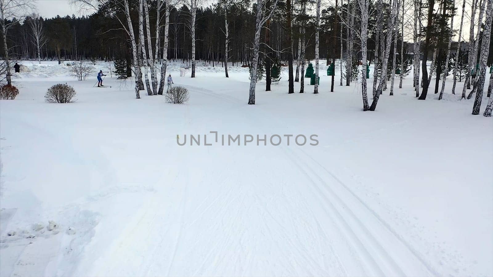 Ski race on track in winter. Footage. Top view of competing professional skiers in colorful costumes riding on track. Winter cross-country skiing competitions.