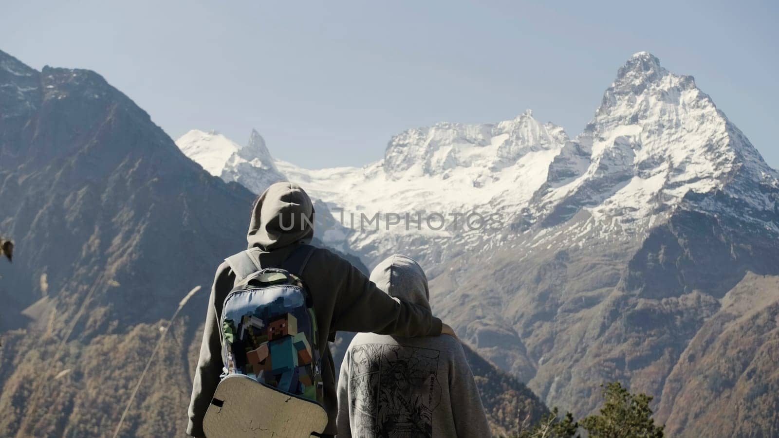 Family walk in the mountains. Creative. A young mother and son climbed to the top of the mountain and enjoy the sunny landscape. by Mediawhalestock