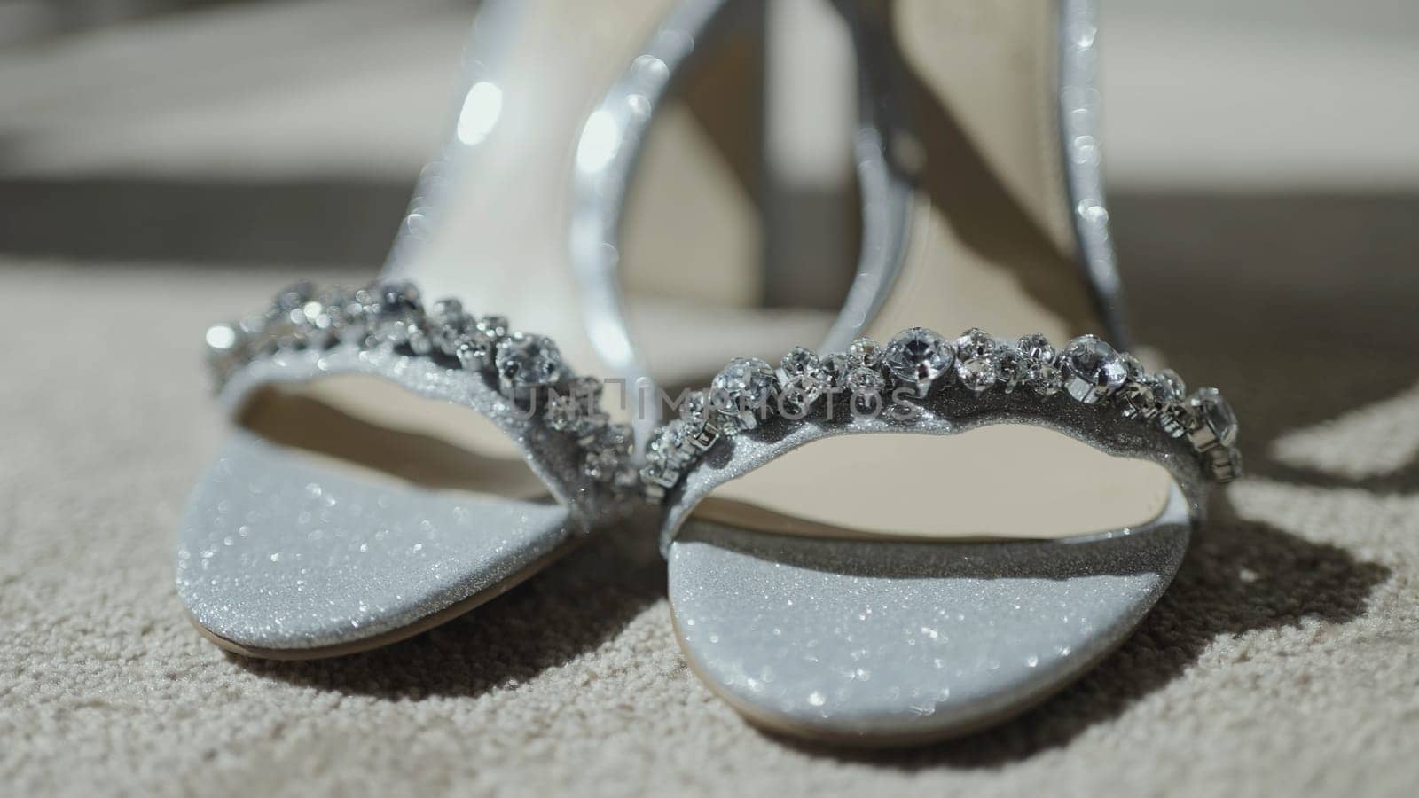Elegant ceremony shoes, bridal sandals with rhinestones. Action. Close up of female new beige shoes