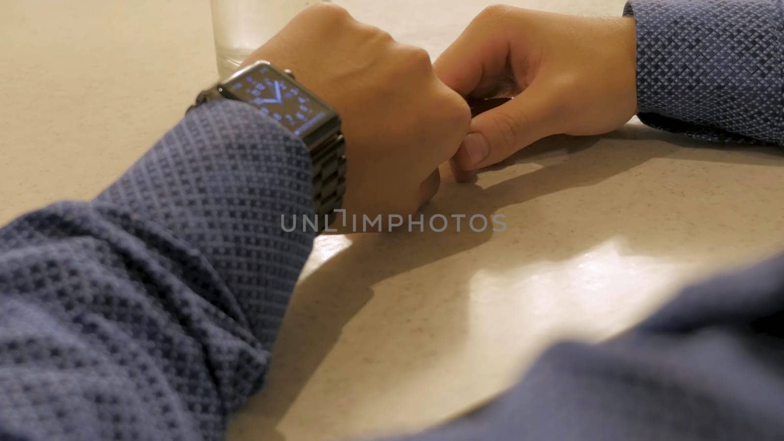 Handsome stylish male managing time on electronic watch. Young man checking modern wrist clock.