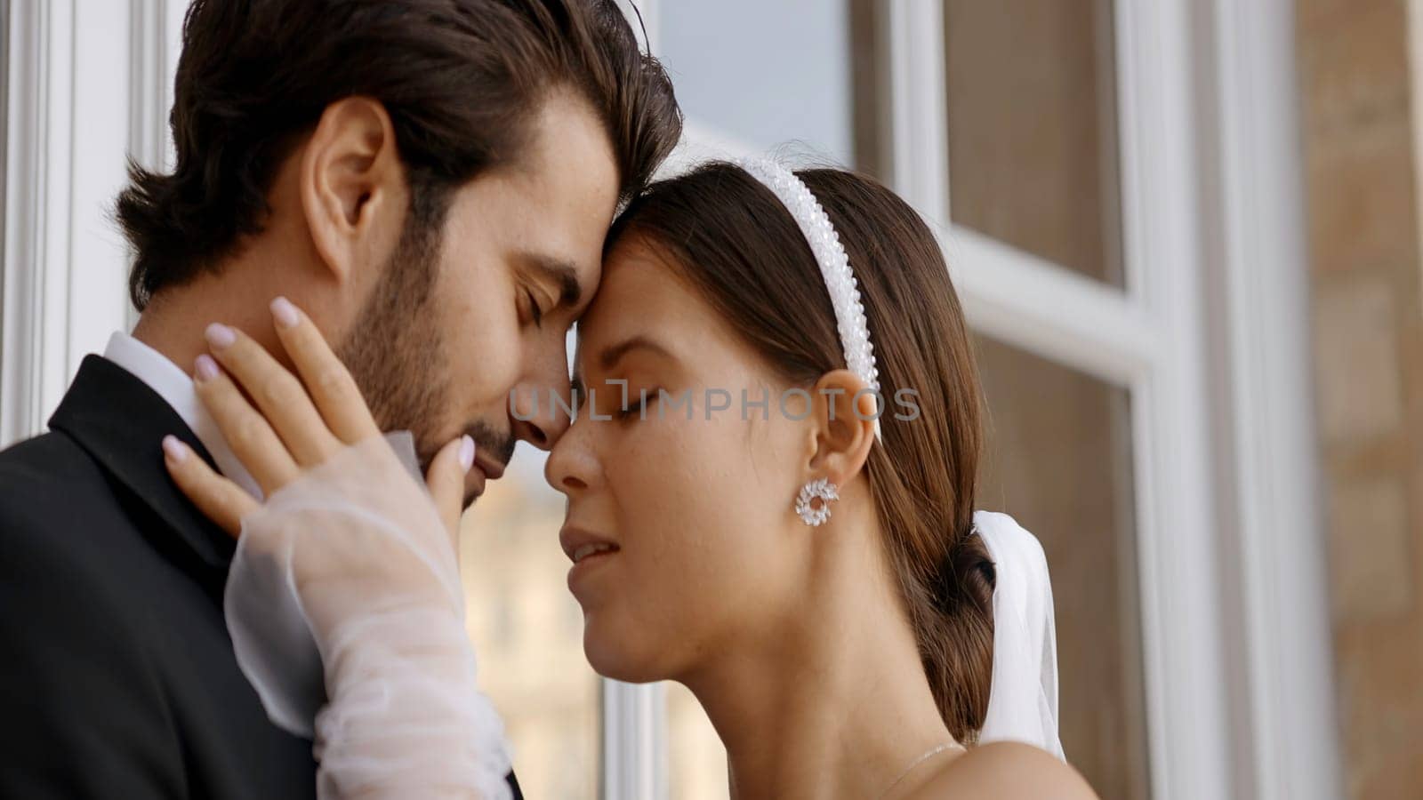 Loving newlyweds posing on their wedding day. Action. Young and elegant man in suit and woman in white dress