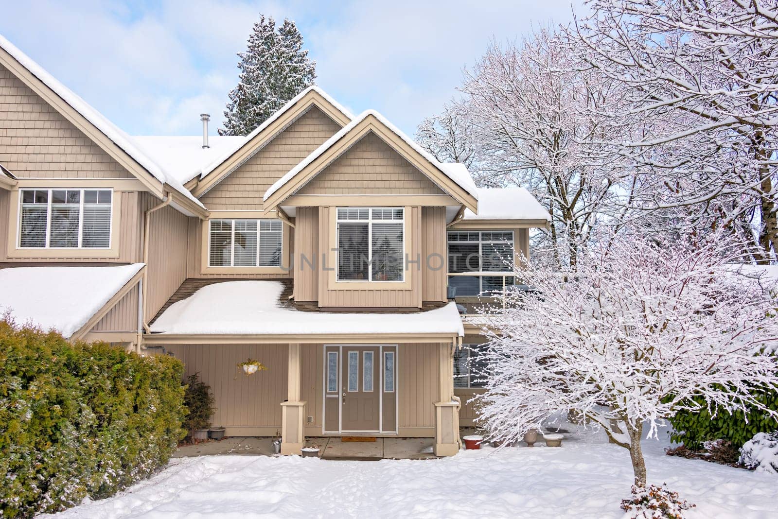 A perfect neighborhood. Entrance of nice residential house on winter season. Snow covered front yard of residential house in British Columbia, Canada