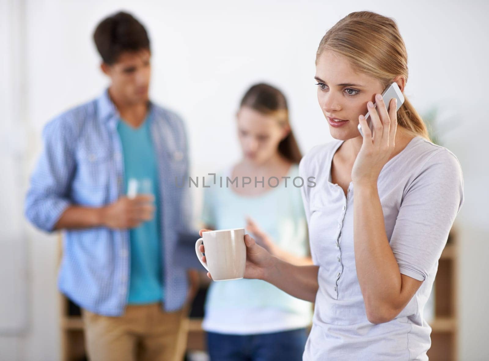 Businesswoman, phone call and drinking coffee, networking and communication on technology in office. Female person, tea and speaking on smartphone in workplace, colleagues and teamwork or internet.