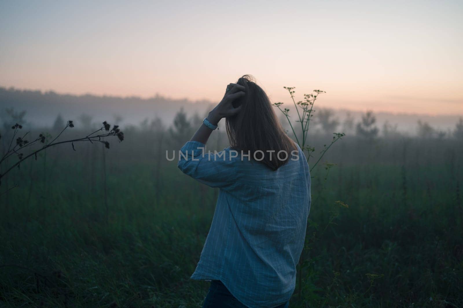 Woman in a field with misty fog